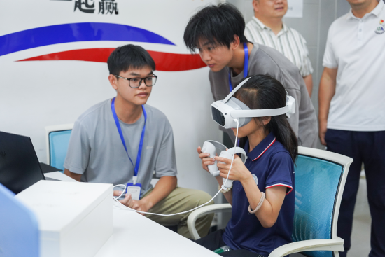 華東交通大學(xué)信息工程學(xué)院學(xué)生正在指導(dǎo)研學(xué)團(tuán)成員體驗VR游戲